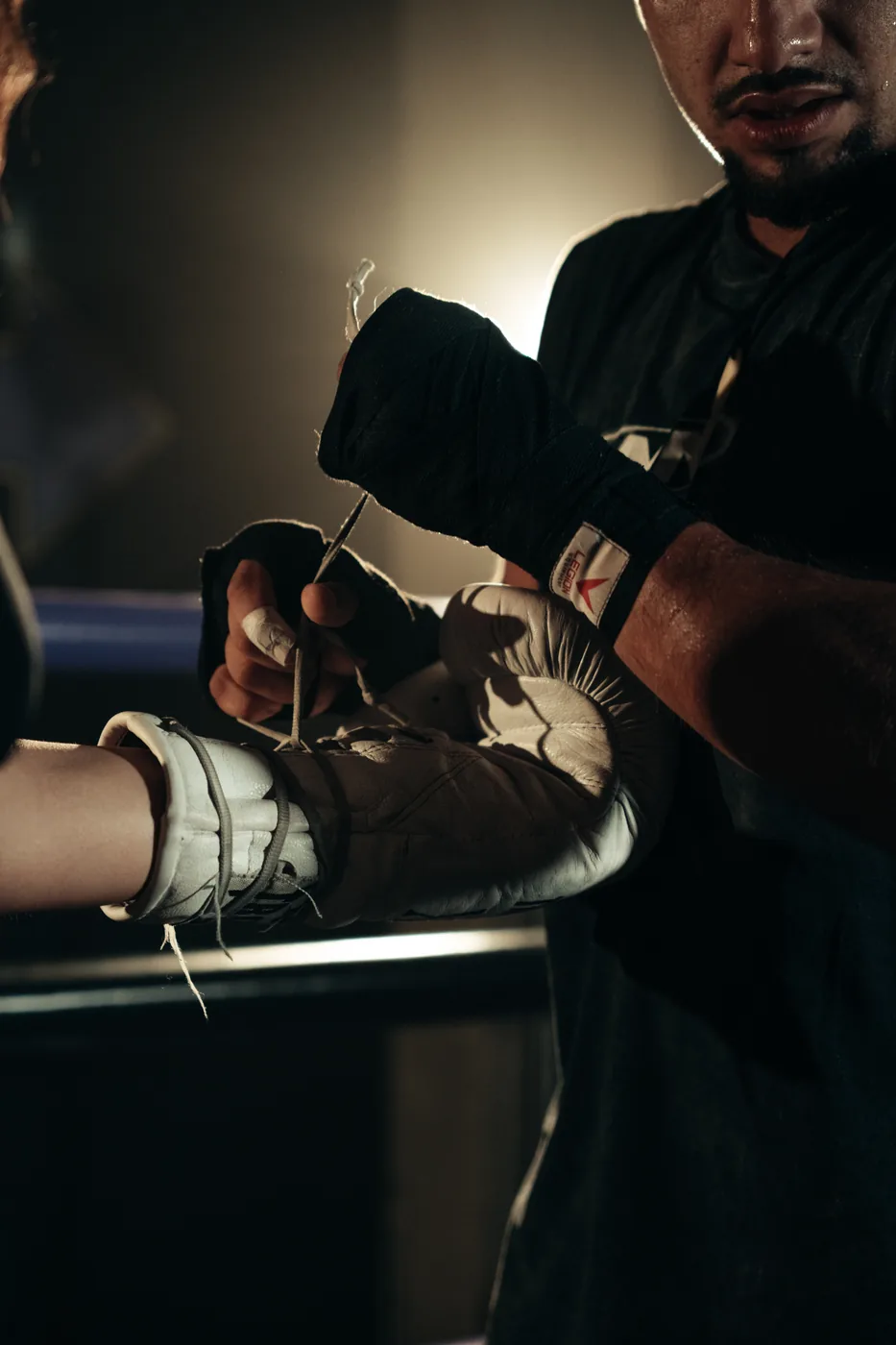 Manos vendadas mientras se atan los guantes de boxeo